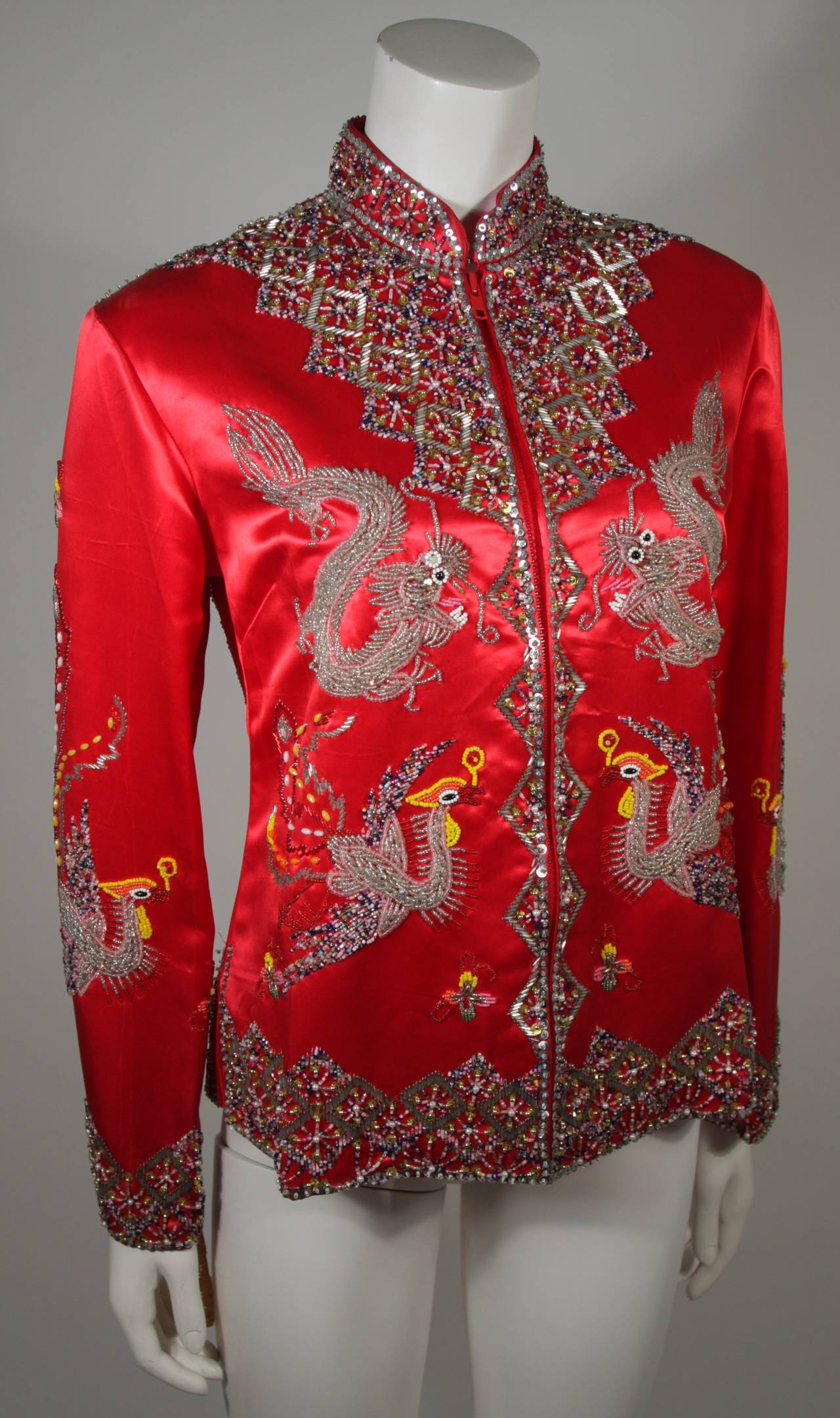 This Dynasty for Neiman Marcus jacket is composed of red embroidered silk that features hand beaded Dragon and Phoenix designs with sequin accents. There is a center front zipper. Comes with original tags and is in excellent condition.

Measures