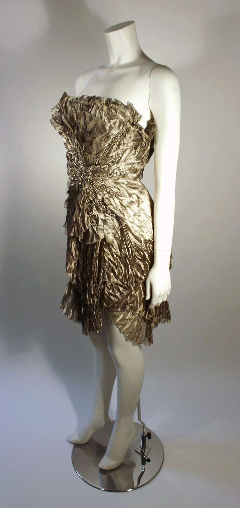 This is an exceptionally designed dress by Marchesa. The antique silver coloring is complimented by a rhinestone side burst, and hand finishing.  

Marked size 2
Measurements (Approximate):
Length: 23.5