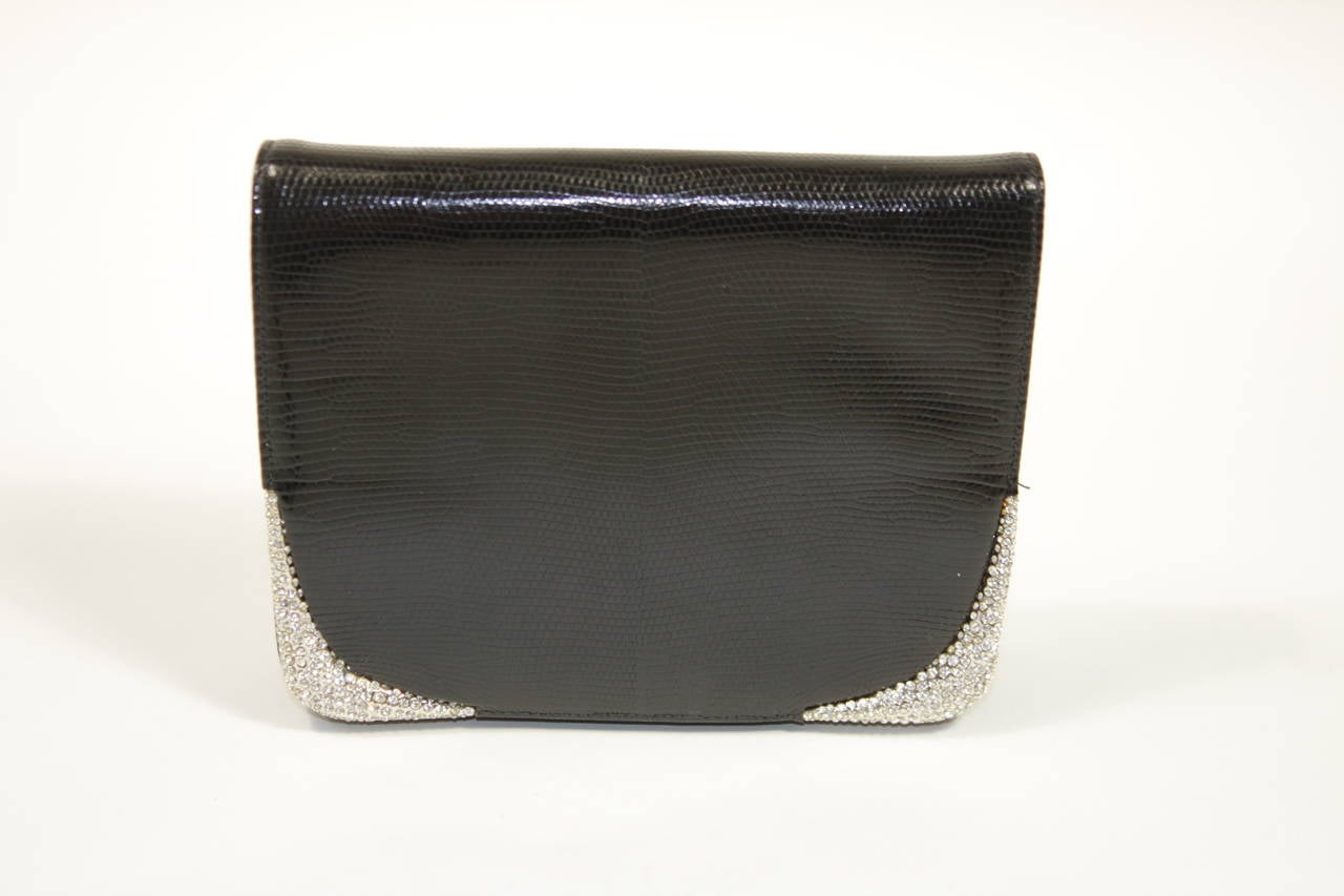 This Valentino design is available for viewing at our Beverly Hills Boutique. We offer a large selection of evening gowns and luxury garments.

This evening clutch is composed of a black lizard which features metal edges adorned with rhinestones.