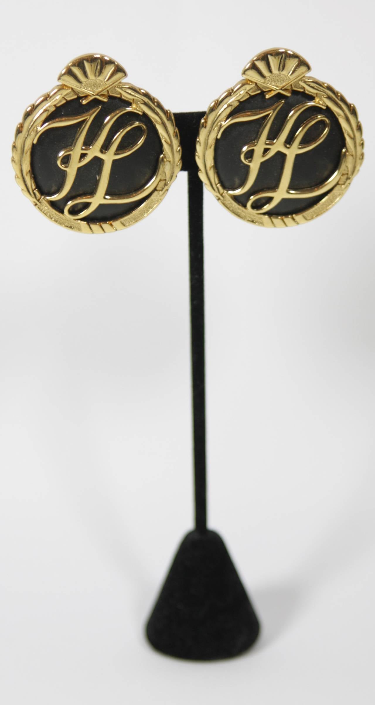 These Karl Lagerfeld earrings are composed of a black and gold tone material. Features the Karl Lagerfeld 
