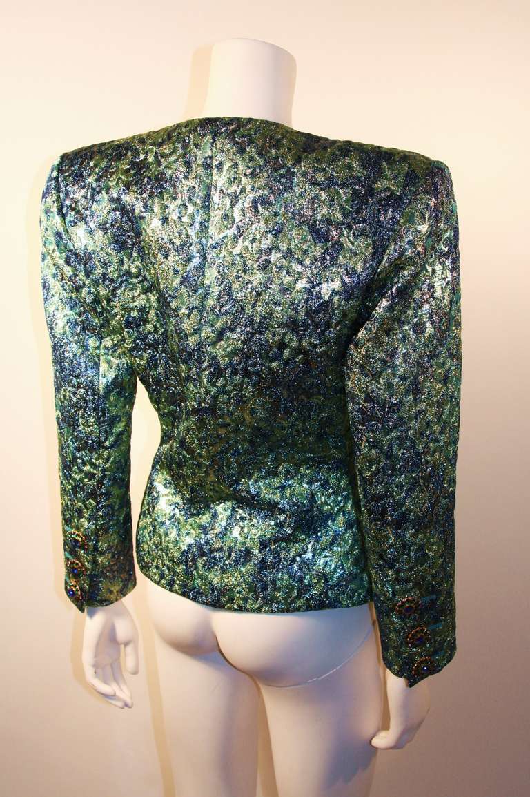 This is an amazing Yves Saint Laurent Rive Gauche Brocade Jacket in hues of green and blue. The very elegant fit is accentuated with beautiful rhinestone buttons with a flash of pink. 

Measurements (Approximate):
Length (Neck to hem): 23 