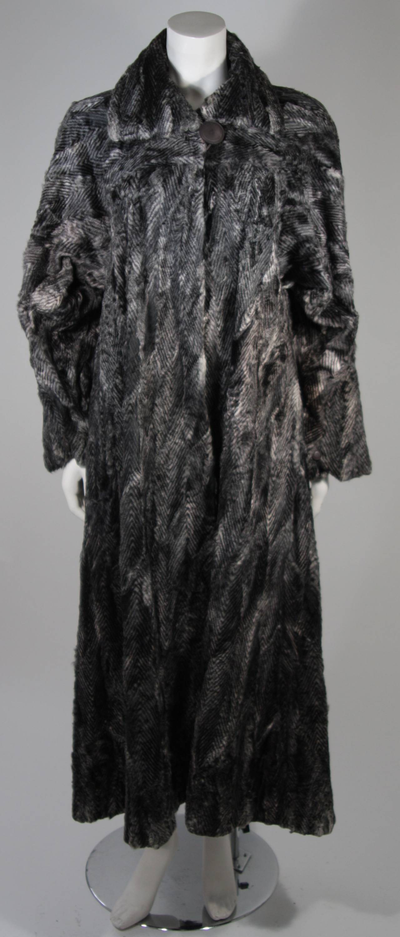 This Fendi coat is available for viewing at our Beverly Hills Boutique. We offer a large selection of evening gowns and luxury garments.

This coat is composed of black and grey sheared lamb with a chevron print. There are center front closures