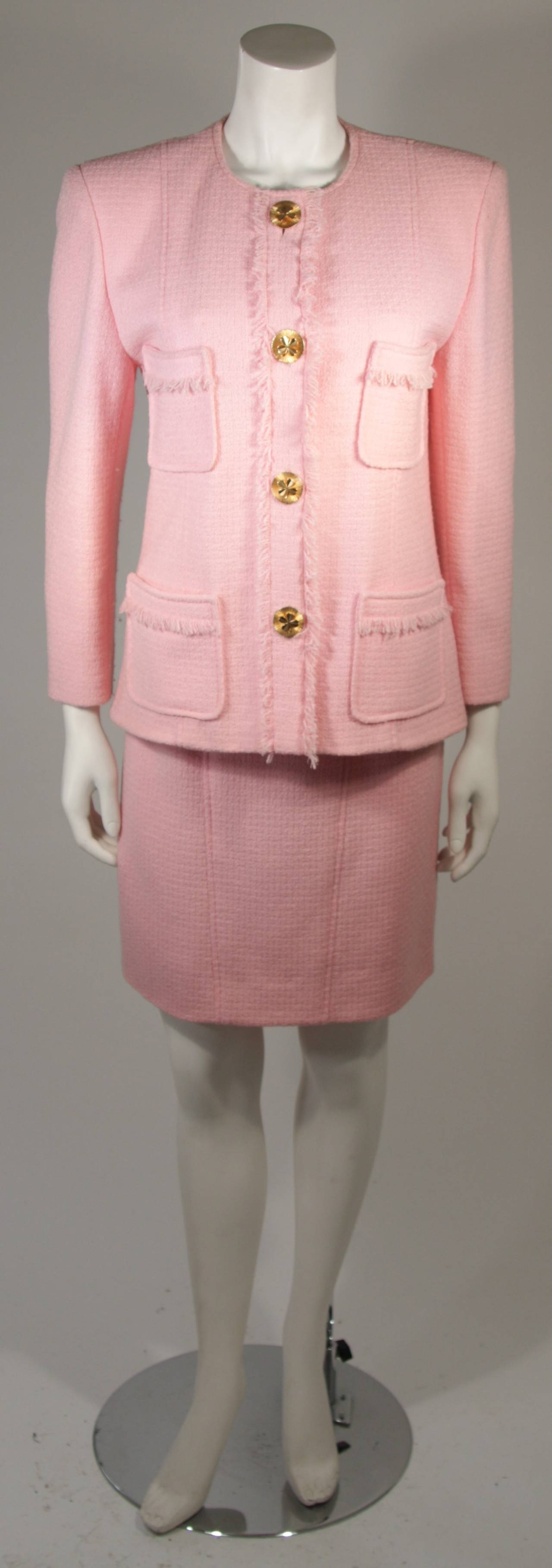 This Chanel skirt suit is available for viewing at our Beverly Hills Boutique. We offer a large selection of evening gowns and luxury garments.

Gorgeous two piece pink wool boucle Jacket and fitted skirt. The jacket has 4 buttons up the center