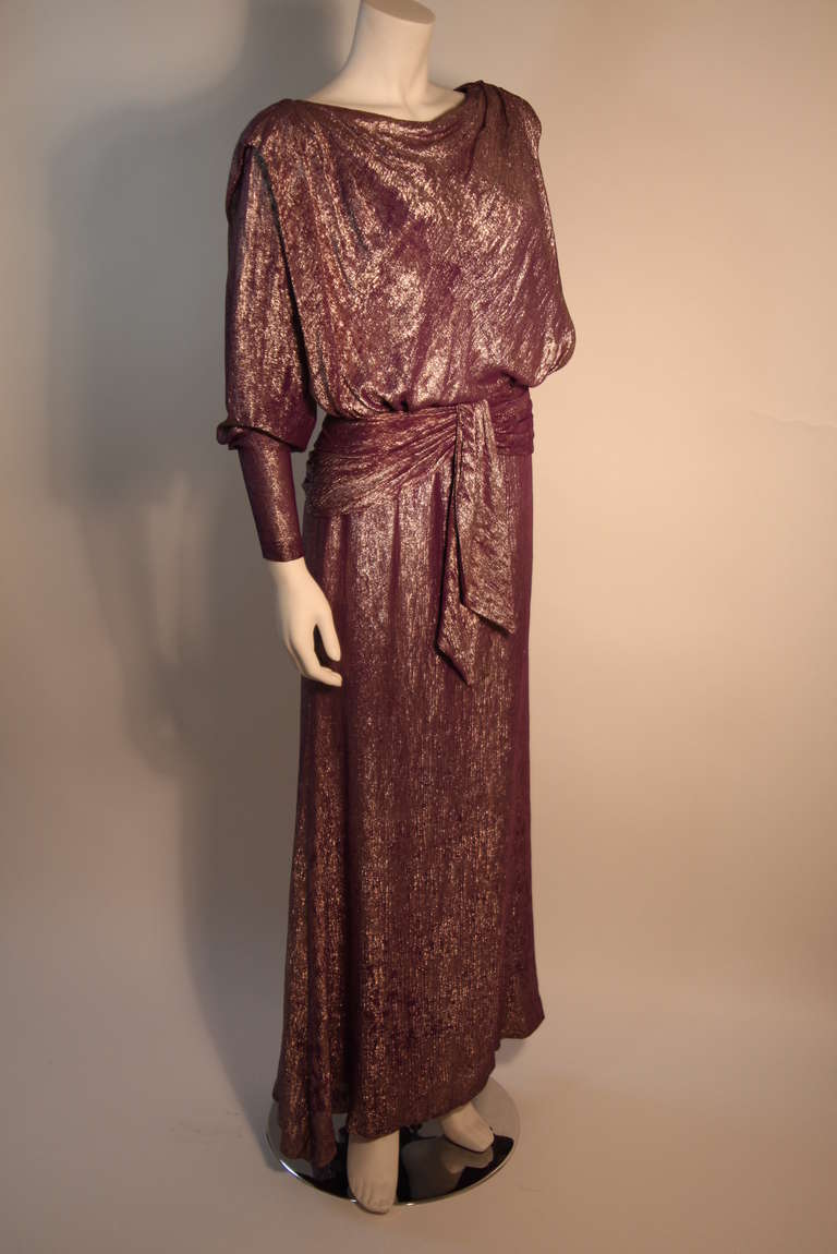 This purple and bronze iridescent drape gown is a Nolan Miller design. It has wonderful hues of purple and golds. It features wonderful draping to accentuate the female form.

Measurements (Approximate):
Length: 57