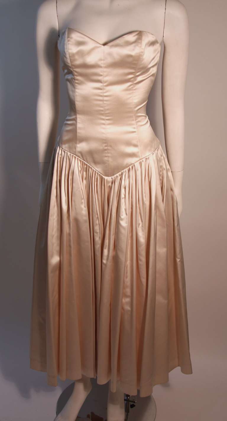 This is a wonderful Norma Kamali Dress. It is made from an ivory colored silk with back waist corset detail.  

Measurements (Approximate):
Length (Back of Neck to Hem): 40