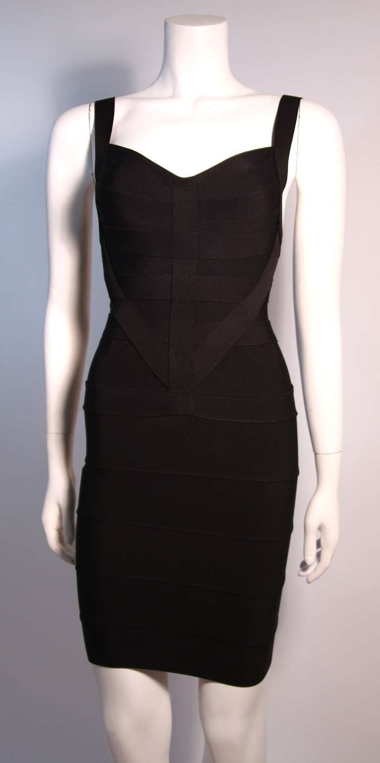 An original Herve Leger Couture black bandage dress with an intricate black on black shield design to the layout of the strips. The dress has a hidden back zipper with 4 hook and eyes at the top.  
Fabric: 90% Viscose 10% Lycra Spandex
Made in
