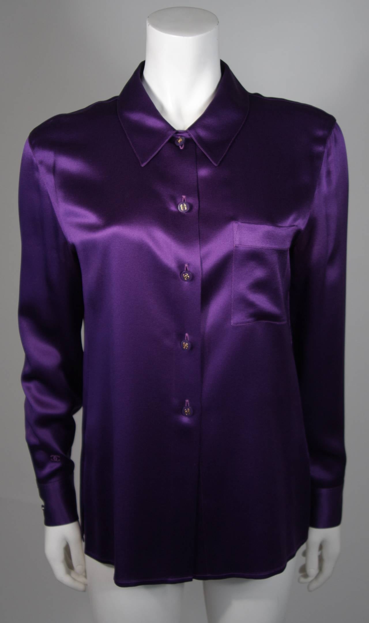 This Chanel blouse is available for viewing at our Beverly Hills Boutique. We offer a large selection of evening gowns and luxury garments.

This blouse is composed of a fine purple silk and features 