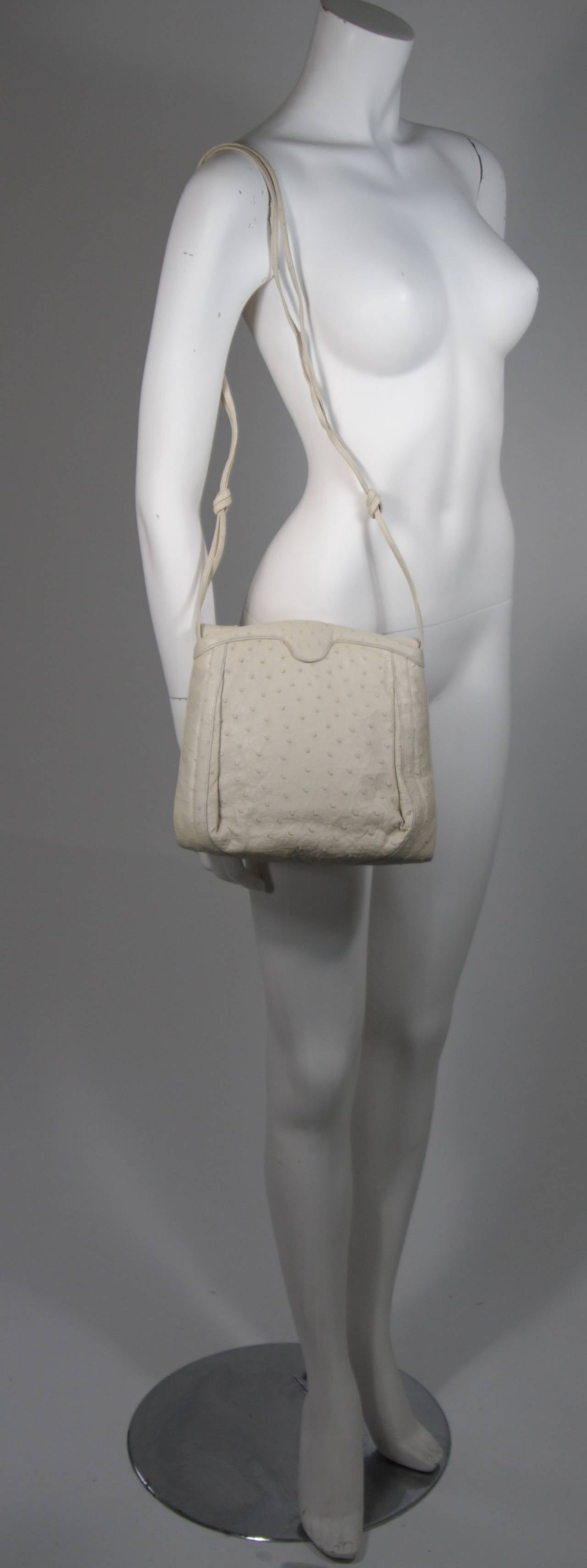 This vintage Judith Leiber is available for viewing at our Beverly Hills Boutique. We offer a large selection of evening gowns and luxury garments.

This handbag is composed of an off-white ostrich skin. There is a magnetic closure and dual
