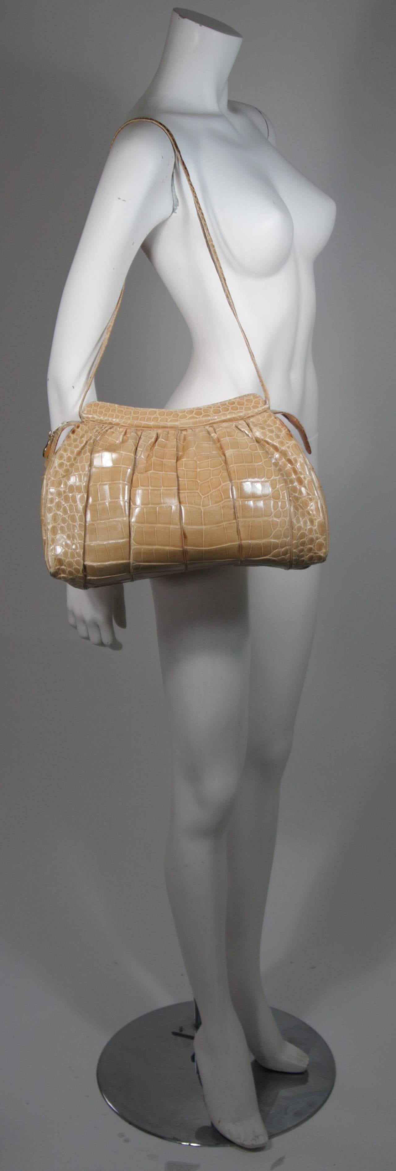 This vintage Judith Leiber is available for viewing at our Beverly Hills Boutique. We offer a large selection of evening gowns and luxury garments.

This handbag is composed of a butter cream hued Alligator. There are two straps and the bag