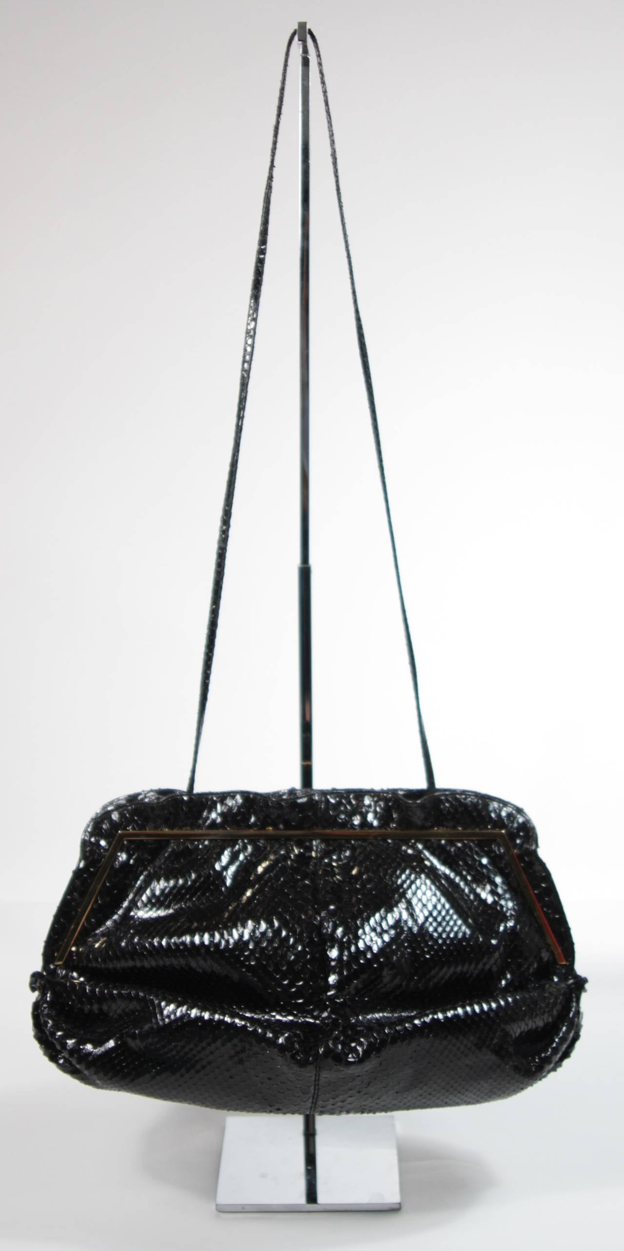 This vintage Judith Leiber is available for viewing at our Beverly Hills Boutique. We offer a large selection of evening gowns and luxury garments.

This handbag is composed of a striking black snakeskin with gold hardware. In excellent condition;