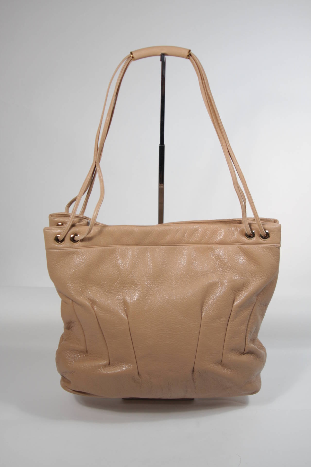 This vintage Judith Leiber is available for viewing at our Beverly Hills Boutique. We offer a large selection of evening gowns and luxury garments.

This handbag is composed of a supple leather with gold hardware. The tote style features double