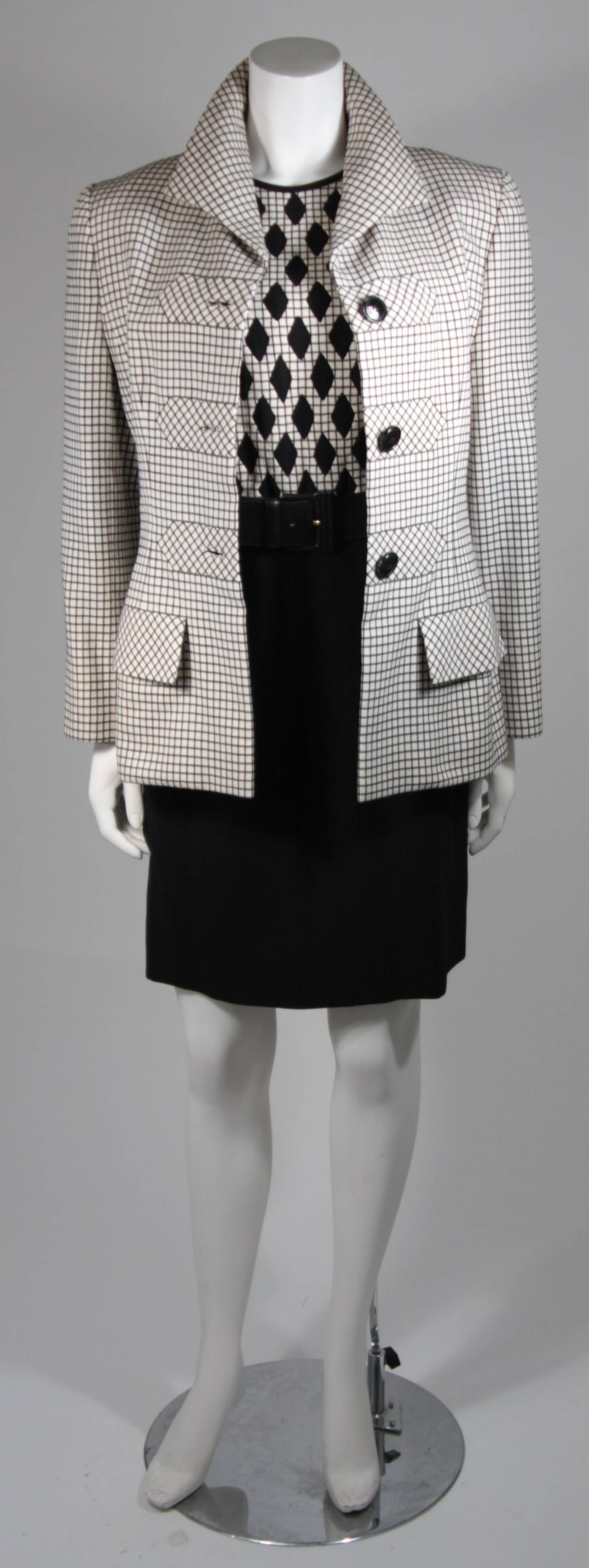 This is an exquisite ensemble by Valentino Couture. The jacket and dress are fully lined in silk and perfectly finished at every turn. 
The dress's focal point is the bodice with the checkerboard pattern inset with contrasting black diamond shapes,