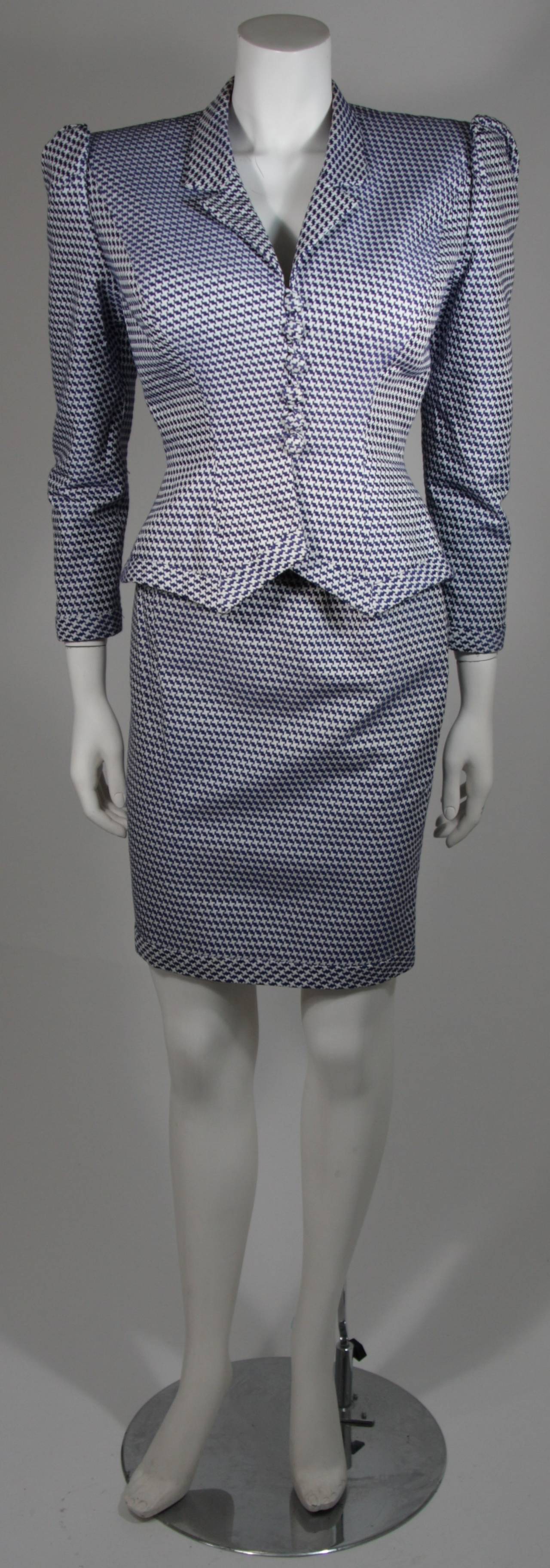 Stunning royal blue and white hounds tooth suit with sculpted shoulders, fabric covered button front, fitted waist with point detail at the hem of the jacket. The skirt is fitted. Both pieces are fully lined in blue silk and hand finished. The body
