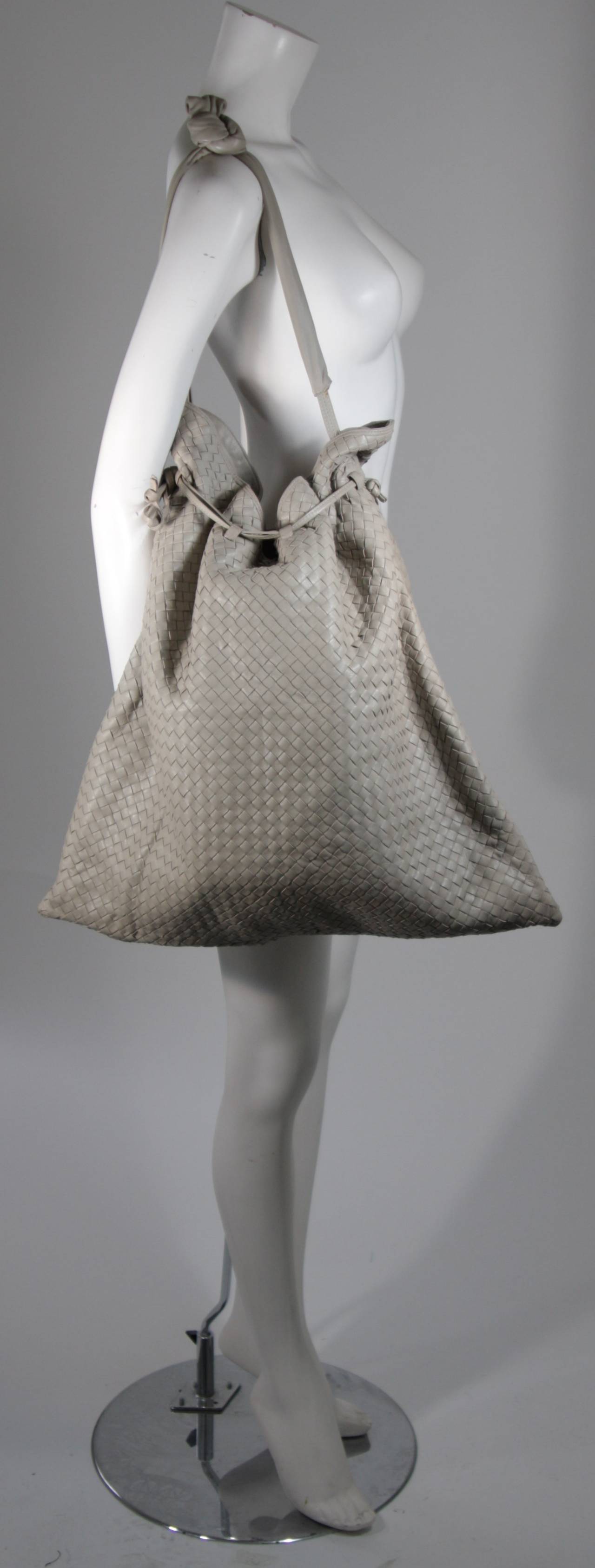 This vintage Bottega Veneta is available for viewing at our Beverly Hills Boutique. We offer a large selection of evening gowns and luxury garments.

This handbag is composed of a supple taupe leather in the classic Bottega Veneta interwoven