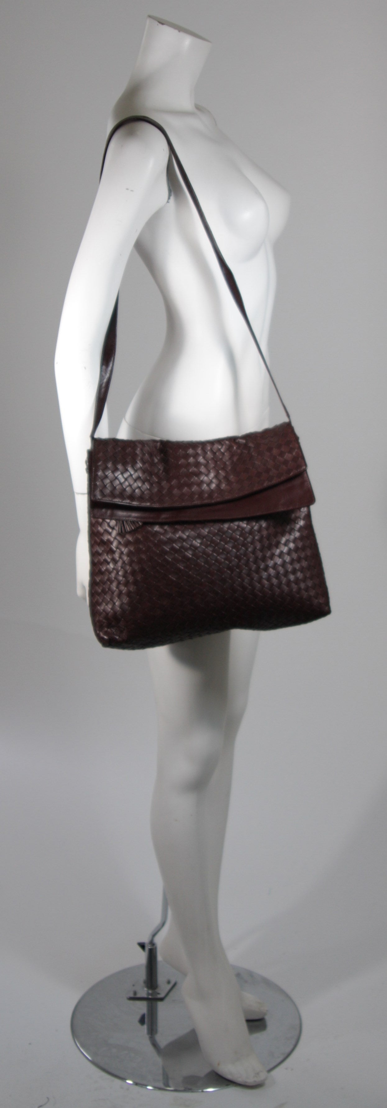 This vintage Bottega Veneta is available for viewing at our Beverly Hills Boutique. We offer a large selection of evening gowns and luxury garments.

This handbag is composed of a supple rich brown woven leather. The purse features one exterior