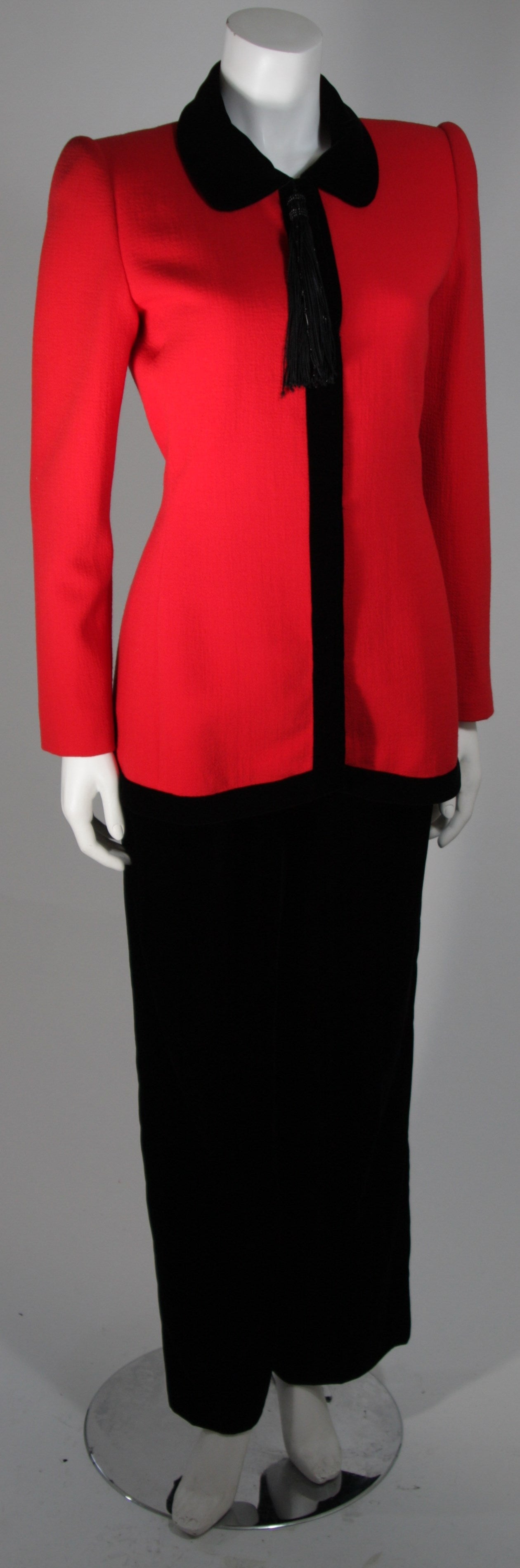 This Carolina Herrera Couture design is available for viewing at our Beverly Hills Boutique. We offer a large selection of evening gowns and luxury garments.

This suit is composed of a red wool which features a velvet trim jacket and black velvet
