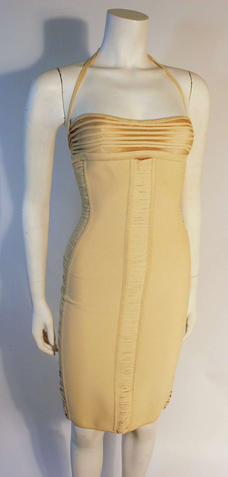 This is a wonderful Herve Leger cream halter bandage dress. This mini dress features a back zipper and hand tacked strips backed by a sheer metallic material. Wonderful for day and night looks. 

Measurements 
Unstretched-Stretched  
Length 37