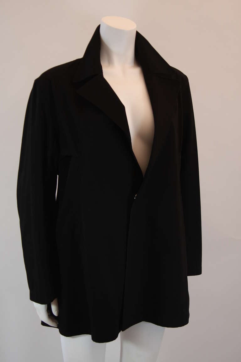 This Yohji Yamamoto jacket is effortlessly chic. A very modern and architecturally fueled take on a classic piece with a beautiful side profile. This jacket features one snap front closure and an adjustable back self belt.

Please feel free to