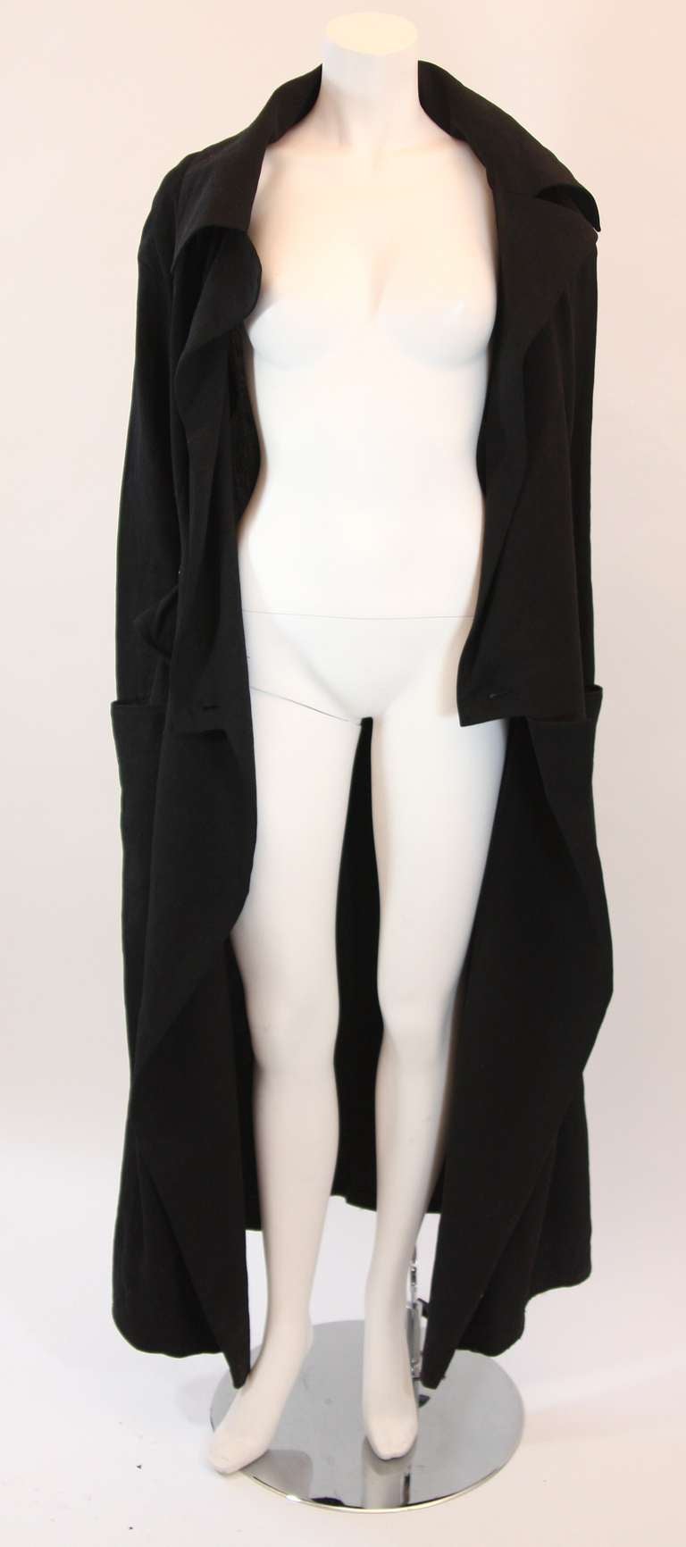 This is a magnificently designed trench coat by Yohji Yamamoto. The large draping pockets at the hip are a dramatic yet subtle detail in true Yamamoto form.  This is a great piece for any season. It features a two button closure which when closed