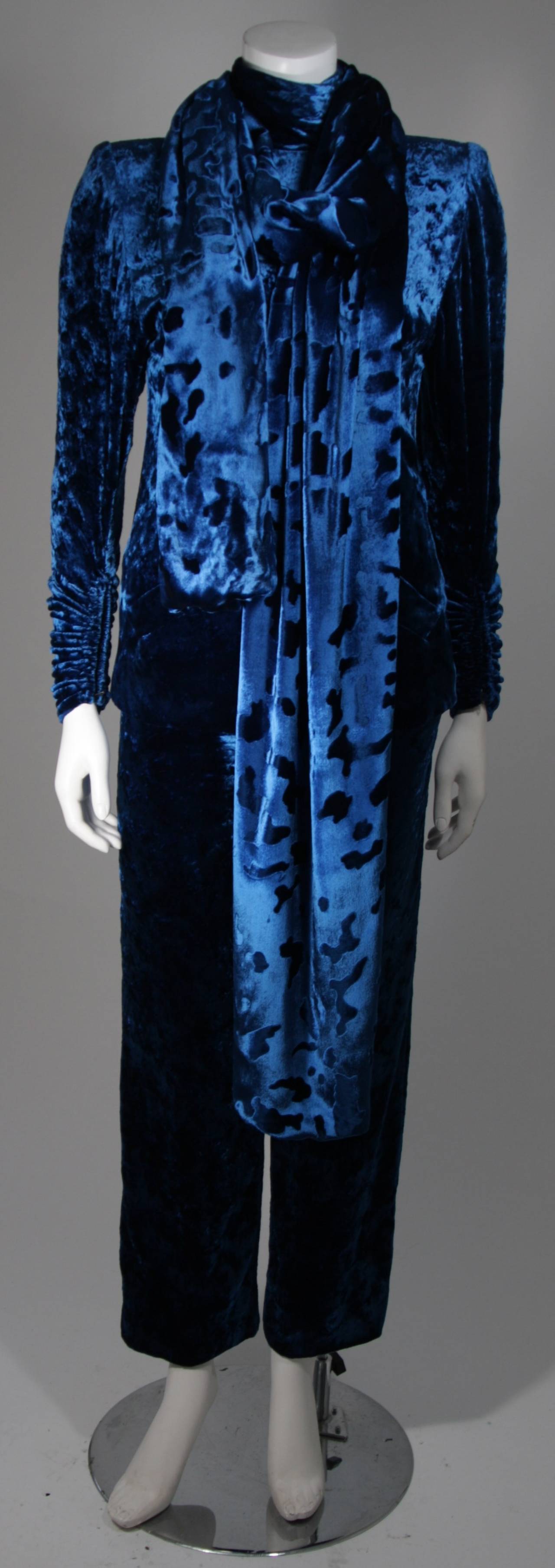 This Galanos Couture design is available for viewing at our Beverly Hills Boutique. We offer a large selection of evening gowns and luxury garments.

This suit is composed of an vibrant blue crush velvet and features a shawl with a textured