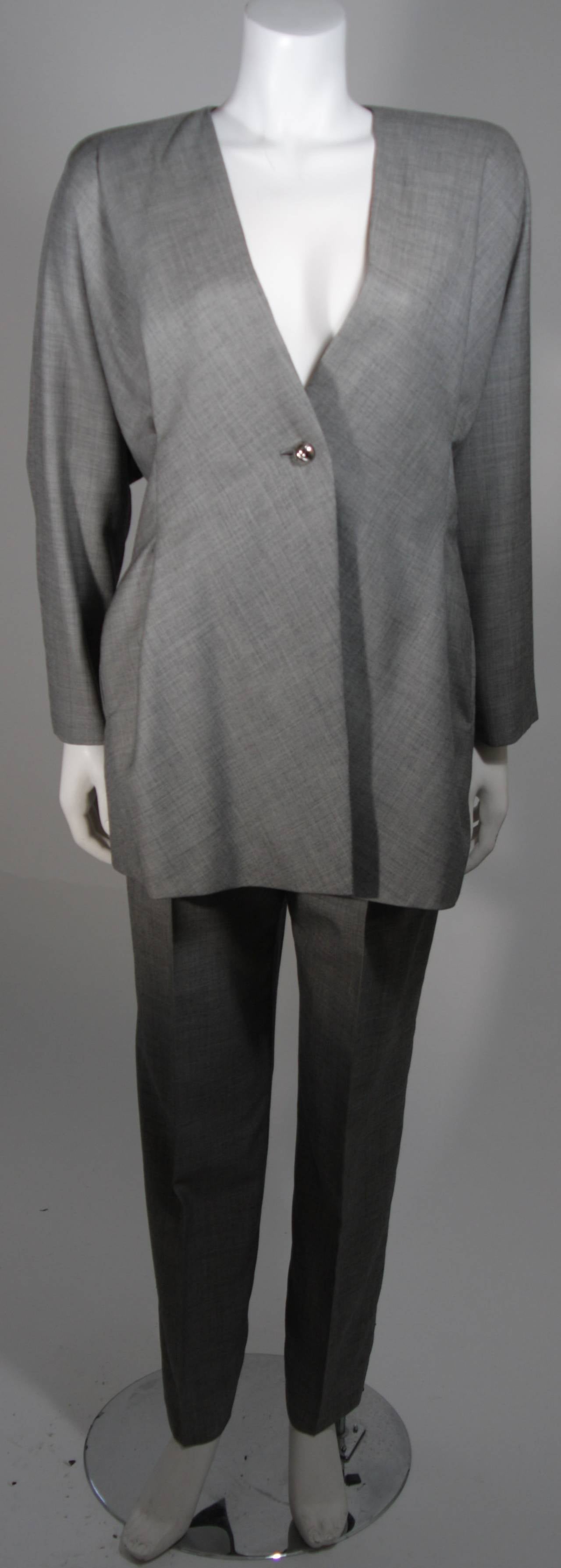 This Galanos Couture design is available for viewing at our Beverly Hills Boutique. We offer a large selection of evening gowns and luxury garments.

This suit is composed of a grey light weight wool. The jacket has an over-sized abstract fedesign