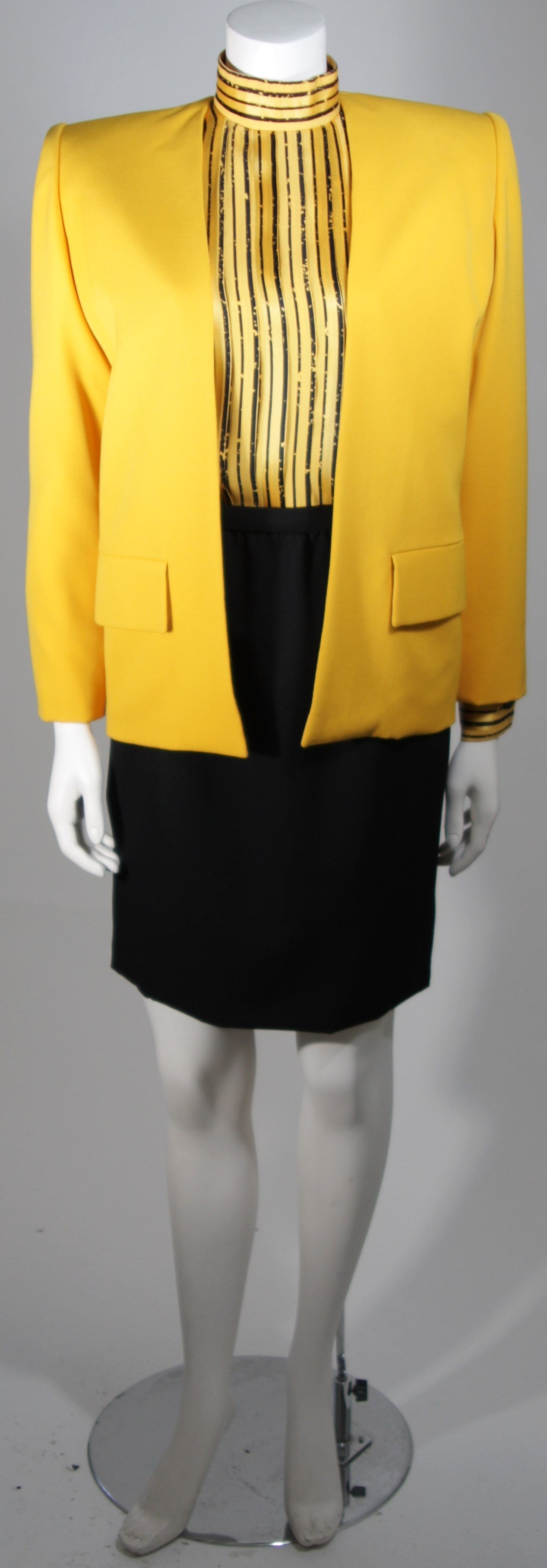 This Galanos Couture design is available for viewing at our Beverly Hills Boutique. We offer a large selection of evening gowns and luxury garments.

This suit features three pieces, the skirt and jacket are composed of a wool. The yellow