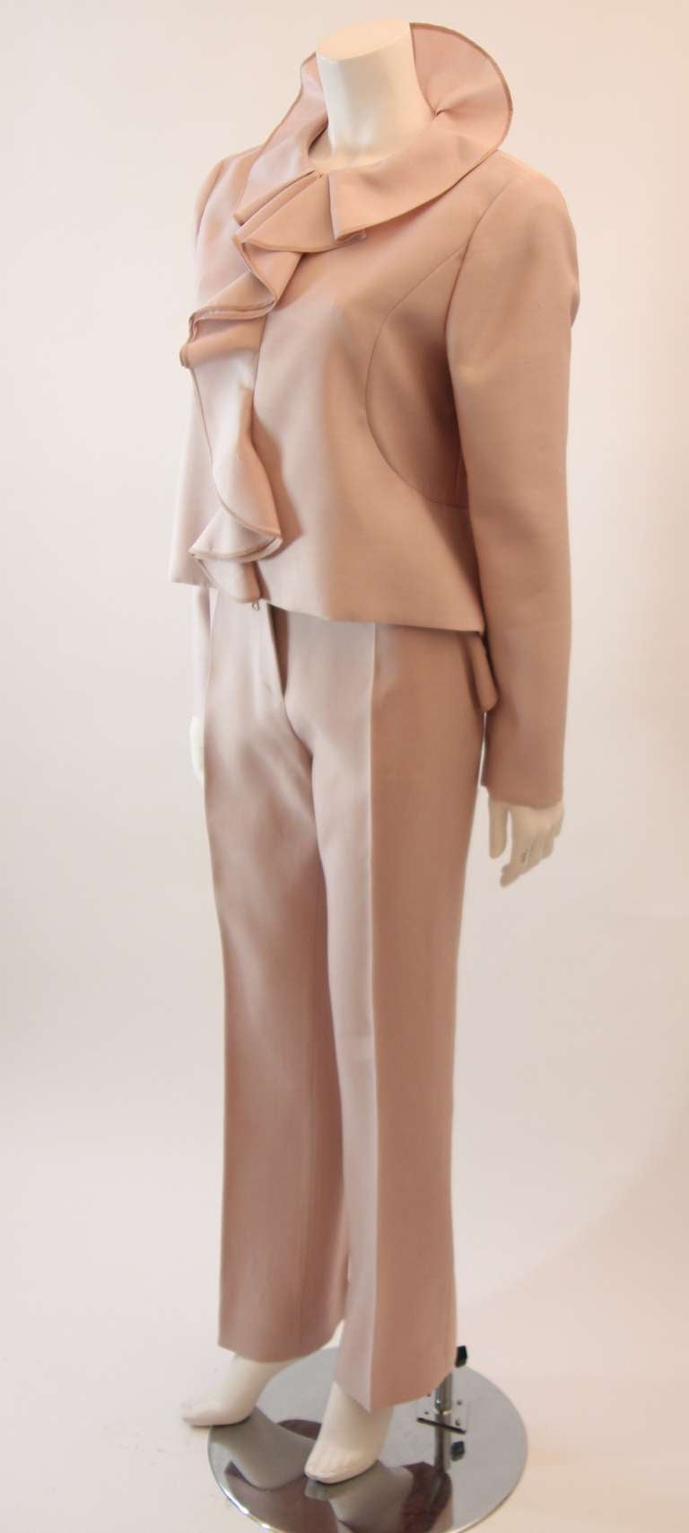 This Valentino is superb. The fantastic cascading ruffles and flower petal design is complimented by the wonderful pink hue of this suit. The suit is composed of a wonderful silk wool blend. The jacket features a zipper closure and a moderate back