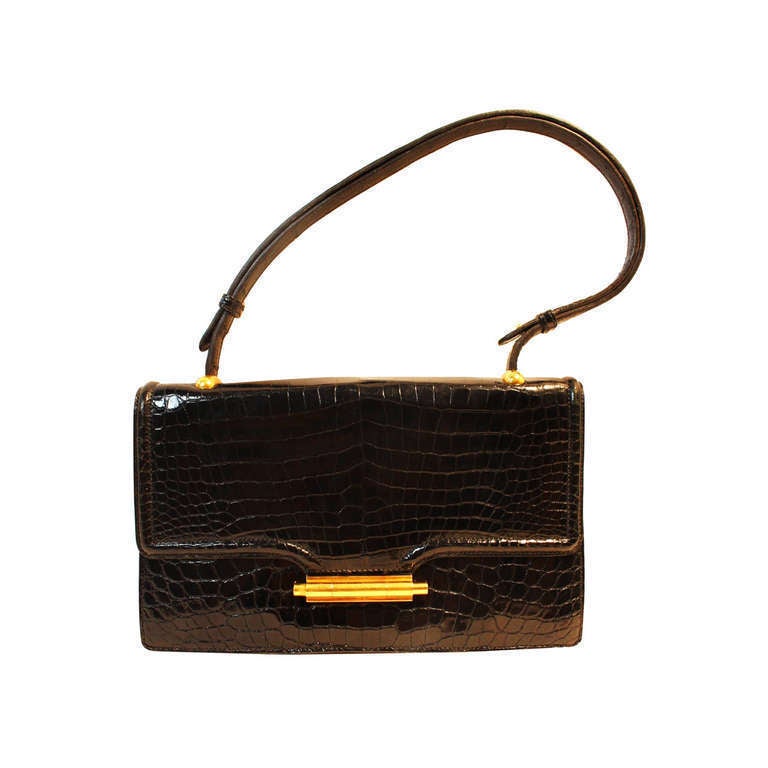 This is a beautifully crafted Hermes Alligator handbag with 10 Karat gold plated hardware, sliding bar closure, interior features a leather backed mirror and leather coin purse as well as several compartments for your credit cards and cash. The