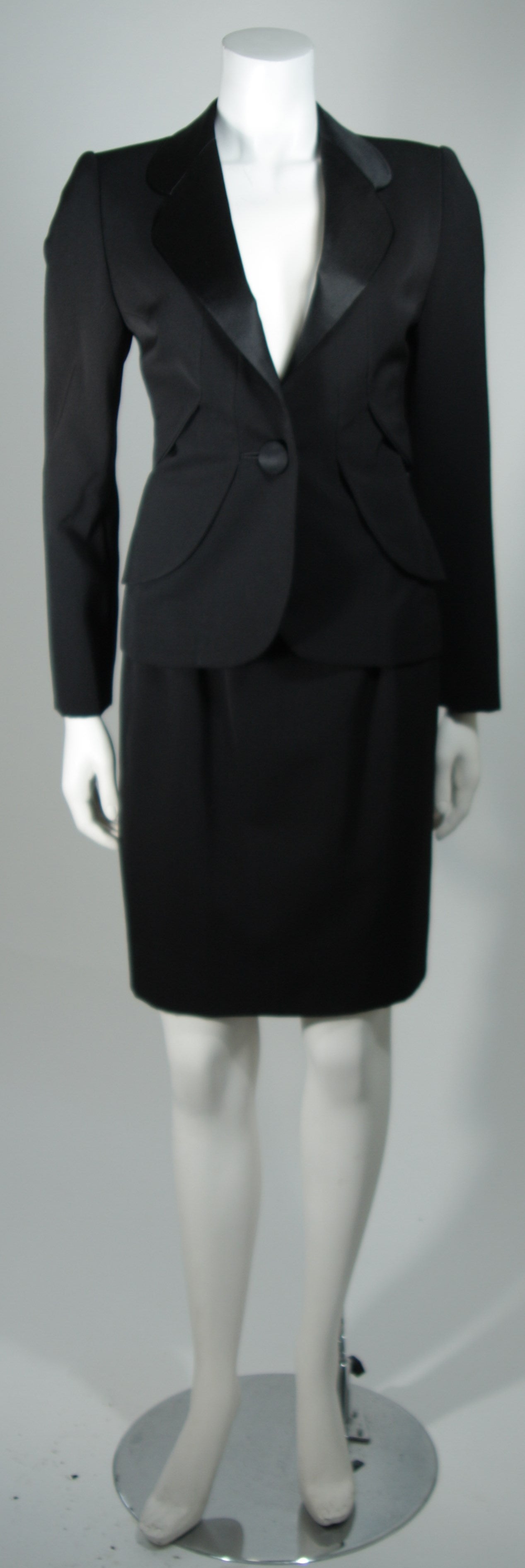 This Galanos Couture design is available for viewing at our Beverly Hills Boutique. We offer a large selection of evening gowns and luxury garments.

This suit is composed of a black wool. The suit features contour streamlines with layered wool.
