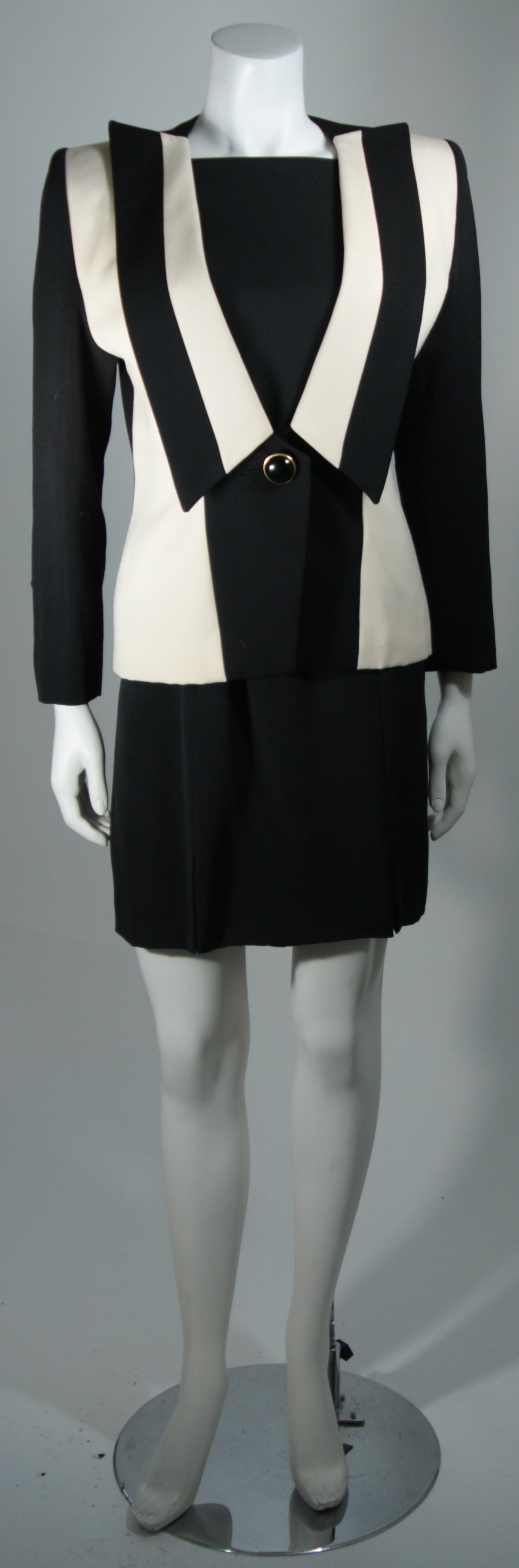 This Galanos Couture design is available for viewing at our Beverly Hills Boutique. We offer a large selection of evening gowns and luxury garments.

This suit jacket is composed of black and white contrasting wool and has a center front button
