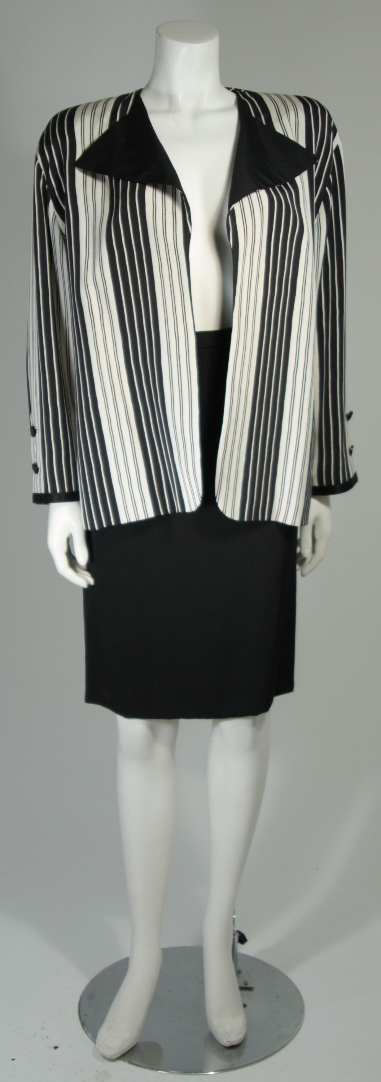 This Galanos Couture design is available for viewing at our Beverly Hills Boutique. We offer a large selection of evening gowns and luxury garments.

This suit jacket is composed of a black and off white stripe silk and features an open style. The