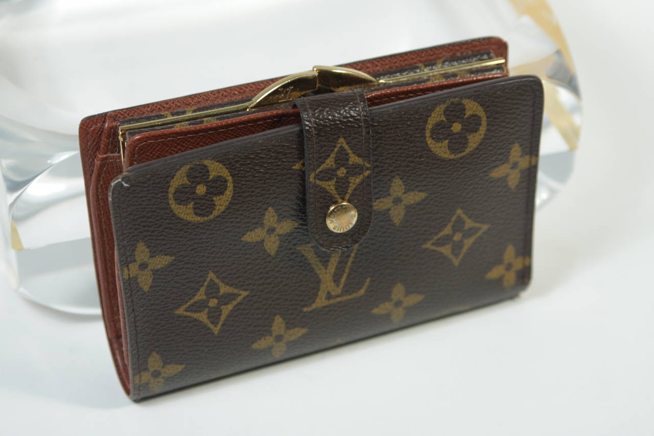 This vintage Louis Vuitton wallet available for viewing at our Beverly Hills Boutique. We offer a large selection of evening gowns and luxury garments.

This Louis Vuitton wallet features the classic monogram style print and gold hardware. In