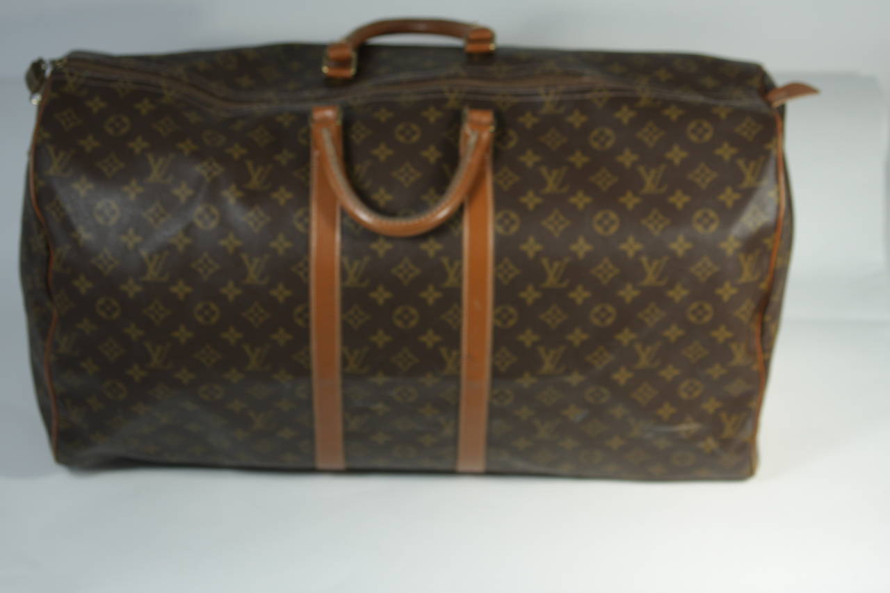 This vintage Louis Vuitton duffle s available for viewing at our Beverly Hills Boutique. We offer a large selection of evening gowns and luxury garments.

This Louis Vuitton duffle features the classic monogram style print and gold hardware. In