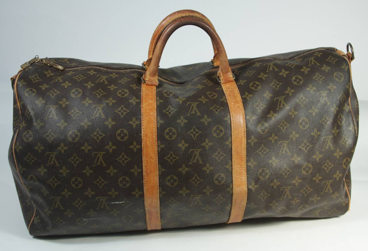 This vintage Louis Vuitton duffle s available for viewing at our Beverly Hills Boutique. We offer a large selection of evening gowns and luxury garments.

This Louis Vuitton duffle features the classic monogram style print and gold hardware. In