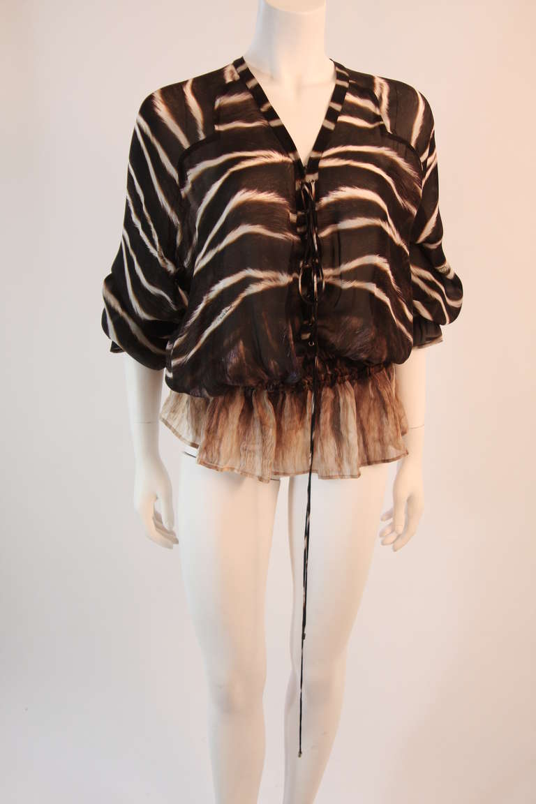 This is a Roberto Cavalli original design. This beautiful chiffon top features a safari color story and lace up detail at the center front. The light weight fabric is perfect for summer. The waist and bell sleeves feature an elastic detail.