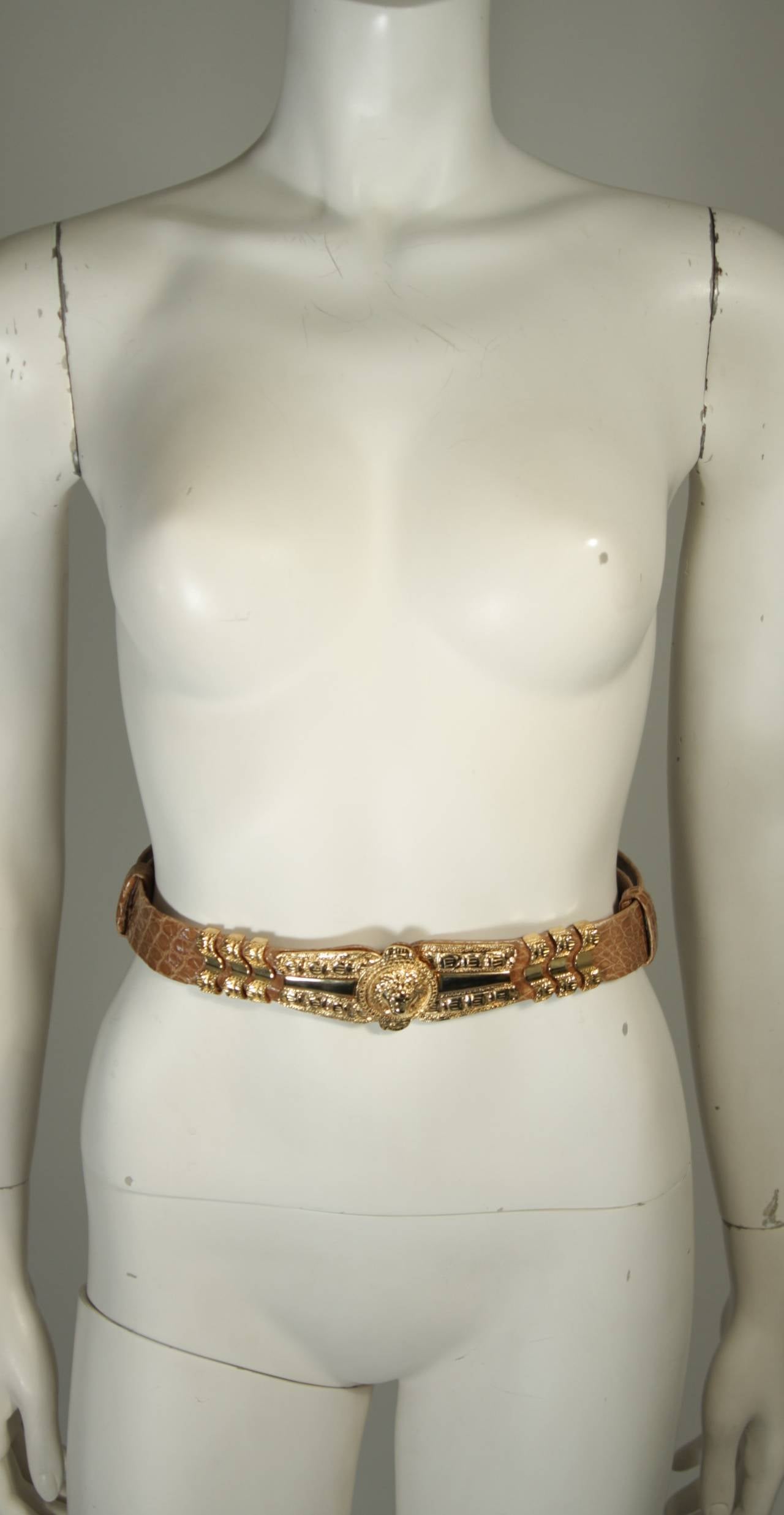 This Judith Leiber is available for viewing at our Beverly Hills Boutique. We offer a large selection of evening gowns and luxury garments.

This belt is composed of a khaki/ camel hued Alligator skin and features gold hardware. The belt buckle is
