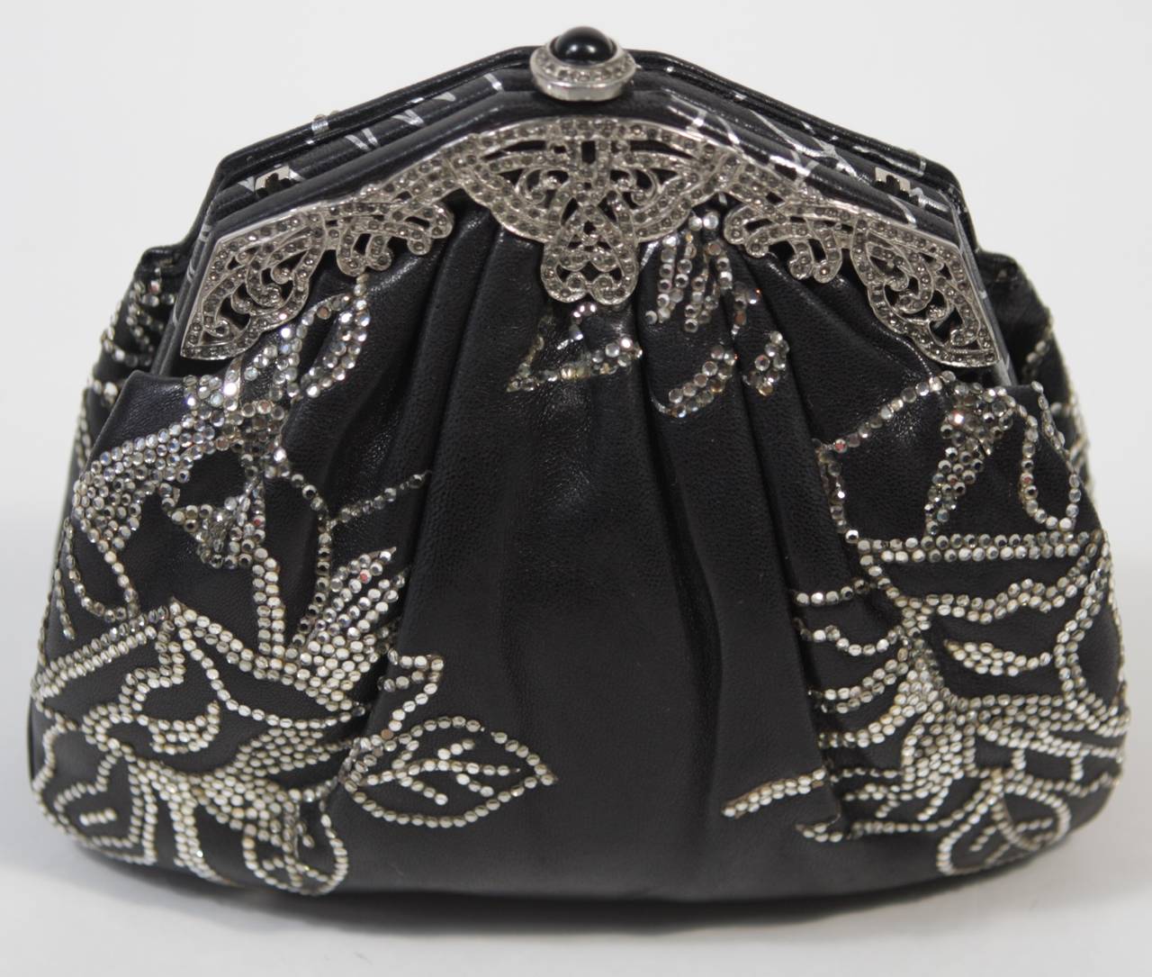 This vintage Judith Leiber is available for viewing at our Beverly Hills Boutique. We offer a large selection of evening gowns and luxury garments.

This handbag is composed of a black leather which features a rhinestone applique in a stunning