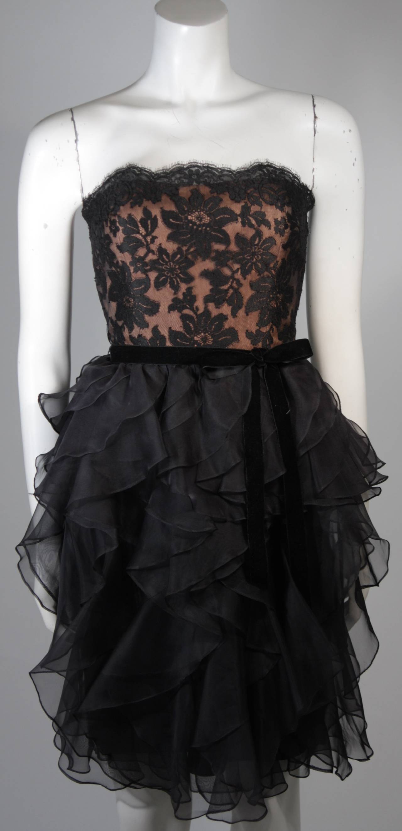 This Jill Richards cocktail dress is composed of black lace and features a lovely layered black silk skirt, comes with velvet bow. There is a center back zipper. In excellent condition.

**Please cross-reference measurements for personal