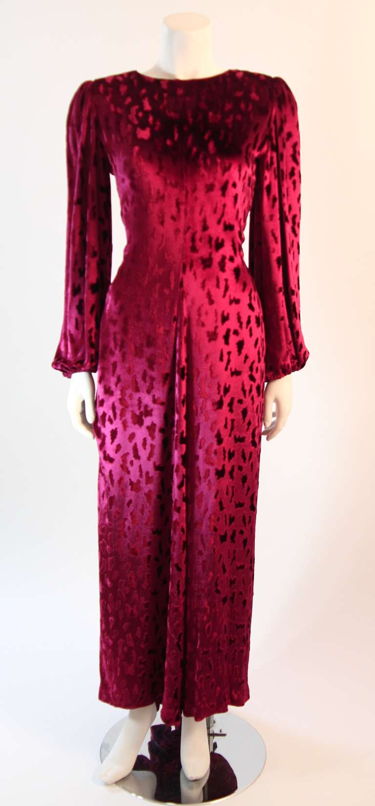 This is a spectacular Oscar De La Renta gown. The gown features a wonderful velvet texture in a beautiful cranberry color. The deep plunging 