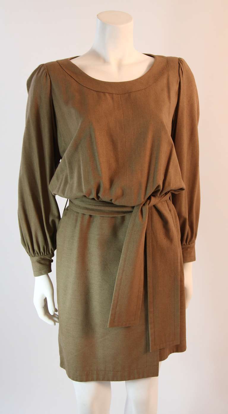 This is a chic Yves Saint Laurent dress. It is composed of 100% silk, woven in a tight raw texture. The dress features long sleeves and wonder scoop neck. Side zipper with snap button closure. Made in France. 