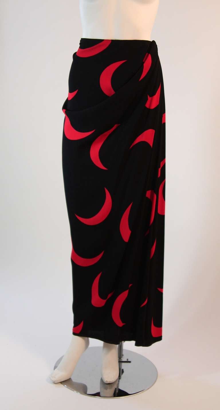 This is a beautiful eye catching Yves Saint Laurent skirt. The glorious high contrast black and cardinal crescent print is complimented by a hip draping detail. The skirt features side detail closure. 

Measures (approximate)
Size 42
Length: