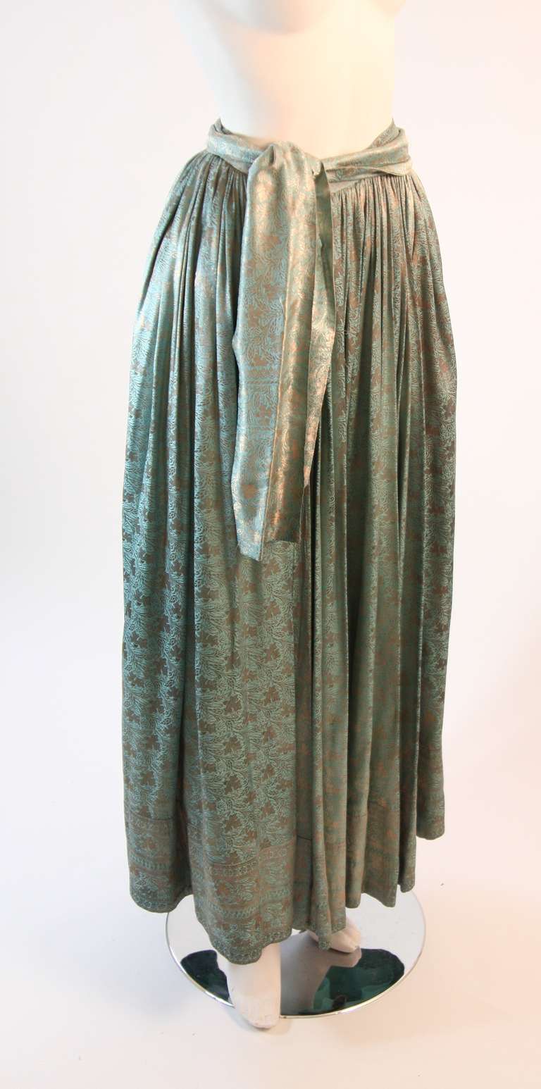 This is a stunning 1950's Brocade skirt. The turquoise hue perfectly compliments the bronze floral motifs. The dress features a zipper closure and waist belt.