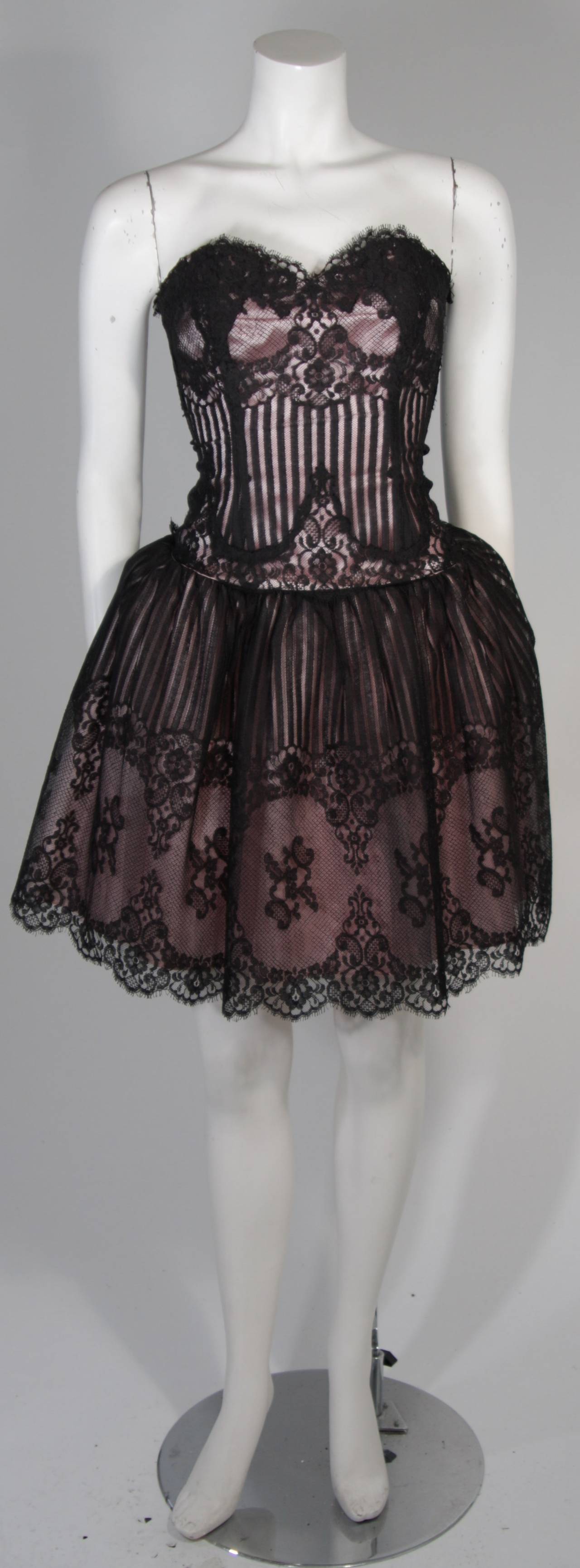 This Victor Costa cocktail gown is composed of black lace and is accented with a pink silk lining. There is a center back zipper closure. In excellent condition. 

**Please cross-reference measurements for personal accuracy.

Measures