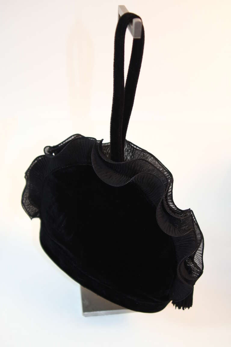 This is a Renaud Pellegrino purse. The purse is composed of a great black velvet, the beautiful circular shape is accented with a wonderful chiffon ruffle fringe. It features a zipper closure and a single strap. 

Measures (approximate)
Strap