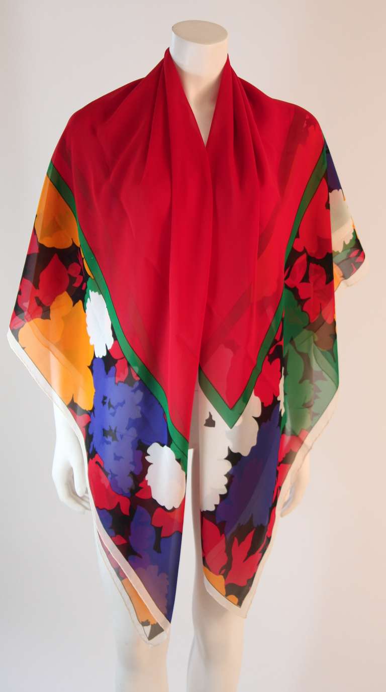 This is a beautiful Yves Saint Laurent silk scarf. The eye catching silk is colored in bold primary colors. This piece works wonderfully as a cover up, a shawl, a scarf, and any other possibility you can think of. Absolutely stunning color