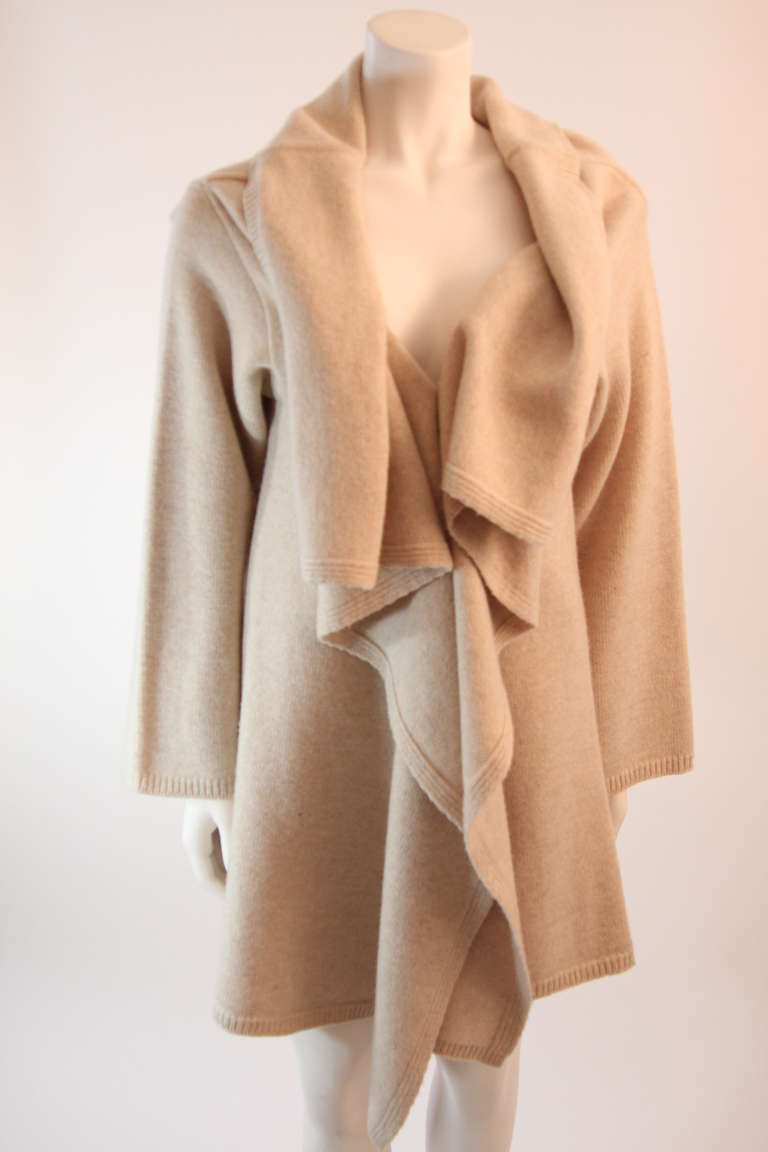 This is a wonderful Valentino virgin wool draped front cardigan. This cardigan is absolutely fantastic and beyond supple. The cream oatmeal color works easily with most options. Dress this garment up or down for a nice cozy summer night or chilly
