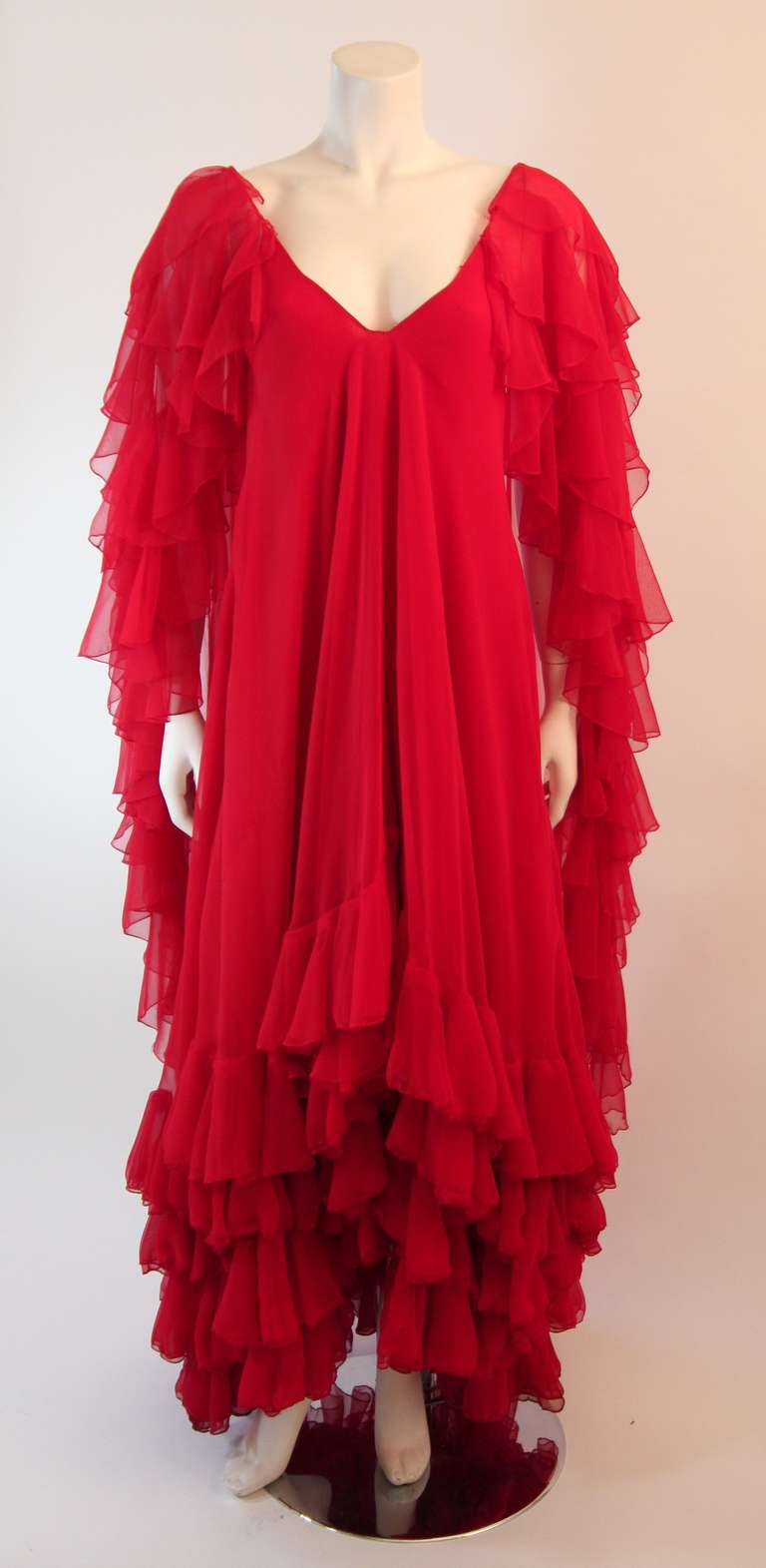 This is the Personal Property of Magda Gabor, sister of Zsa Zsa and Ava Gabor. 
It is a fantastic iconic design by Ruben Panis. This wonderful gown is made with layers of Crimson red chiffon, accented with cascading layers of ruffles. This gown is a