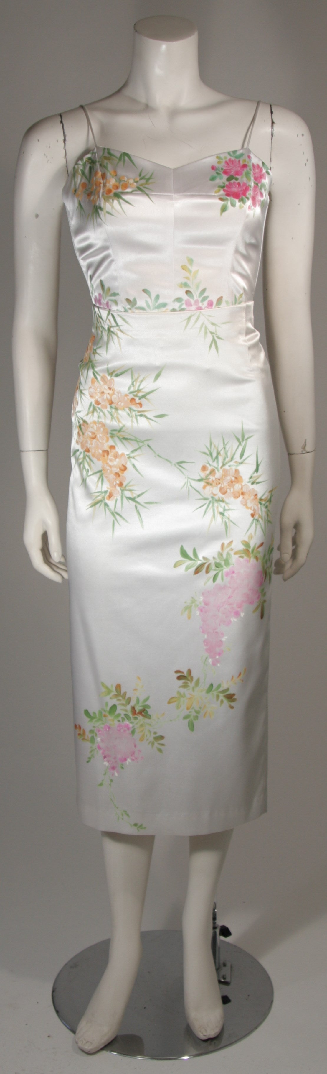 This Mandalay ensemble is fashioned from a beautiful white stretch silk satin with a floral print. The spaghetti strap top features boning and a center back zipper closure. The skirt also features a center back zipper closure. In excellent