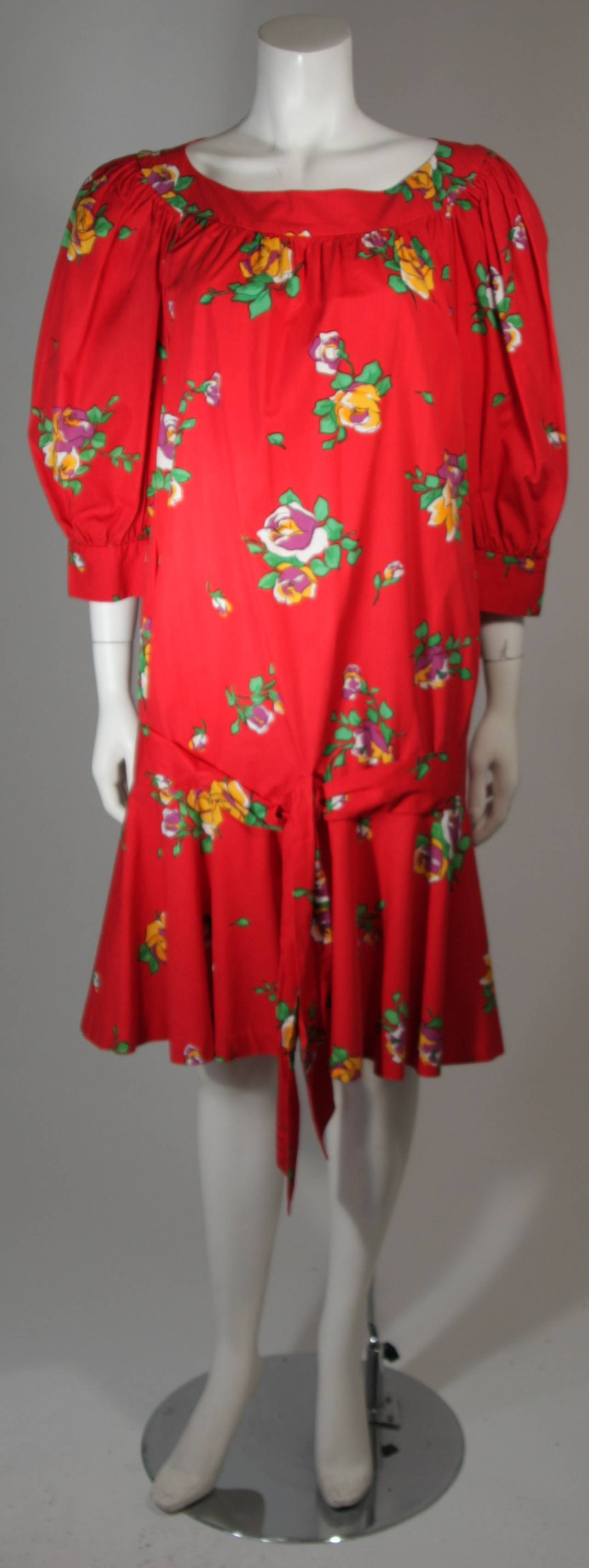 This Yves Saint Laurent dress is composed of a red cotton and features a floral pattern. There are buttons at the sleeves and a hip tie detail. In excellent condition. Made in France.

**Please cross-reference measurements for personal accuracy.