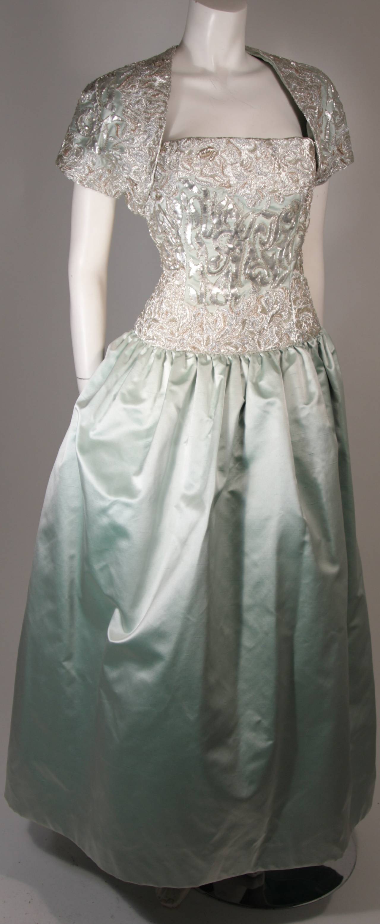 This Oscar De La Renta design is available for viewing at our Beverly Hills Boutique. We offer a large selection of evening gowns and luxury garments.

This ensemble is composed of an aqua/ sea foam green silk and features heavy embellishment. The